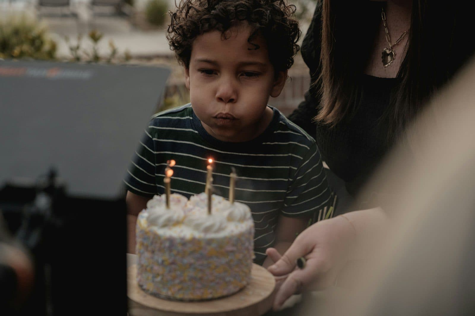 A young boy leaning in to blow out the candles on a small birthday cake.